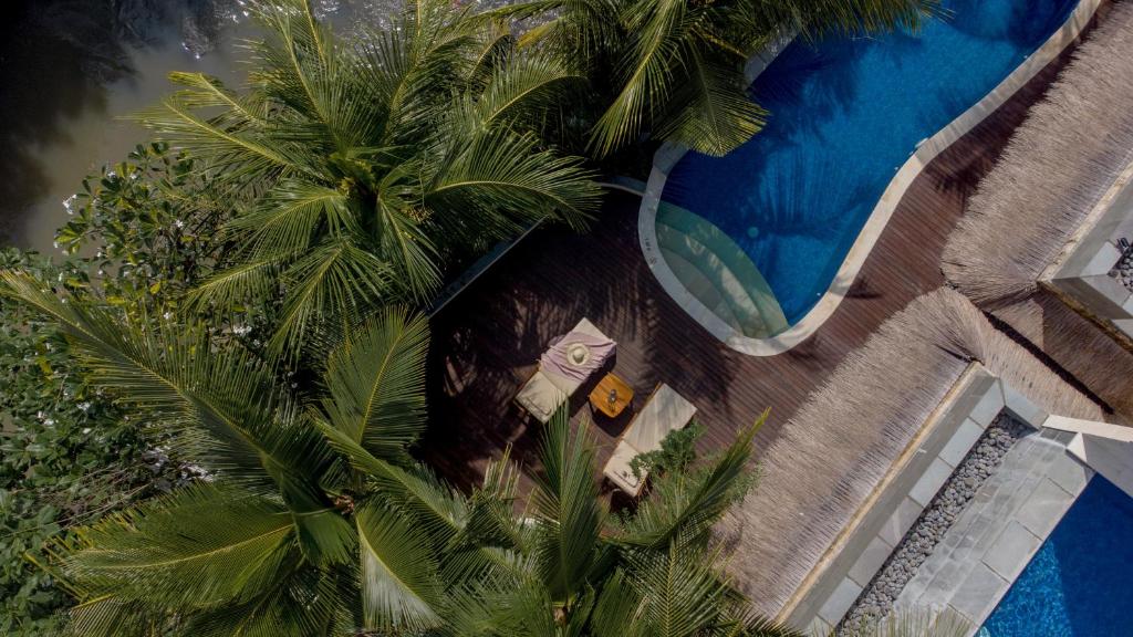 an overhead view of a swimming pool with palm trees at Harsono Boutique Resort Bali in Sanur