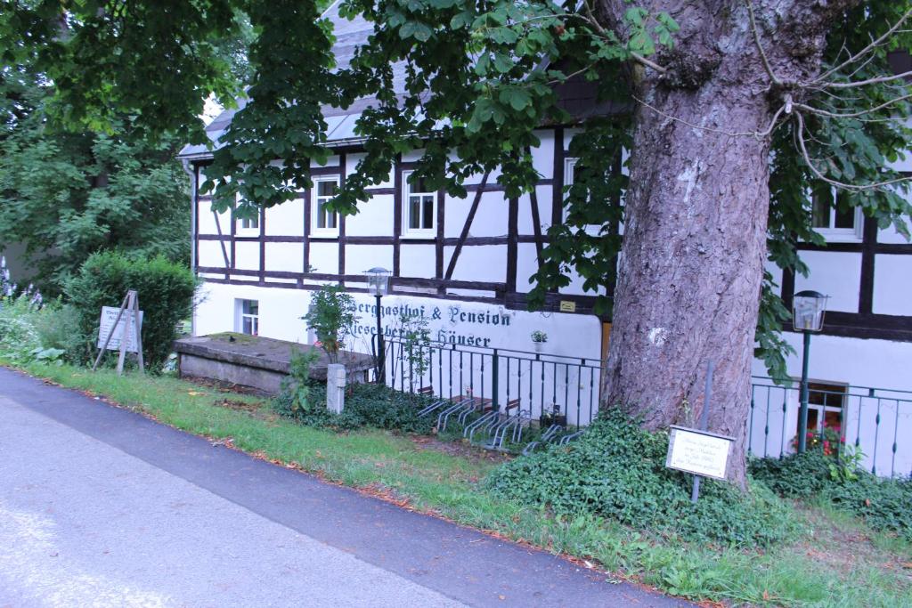 a building with a sign in front of a tree at HerrBerge Pilgerglück in Eibenstock