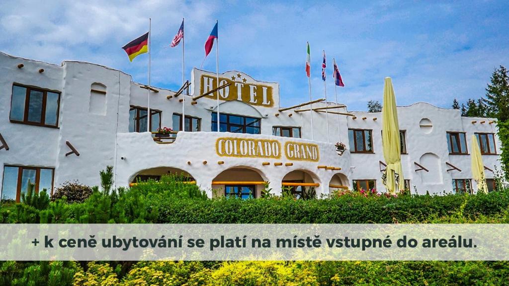a white building with flags in front of it at Hotelový resort Šikland in Zvole