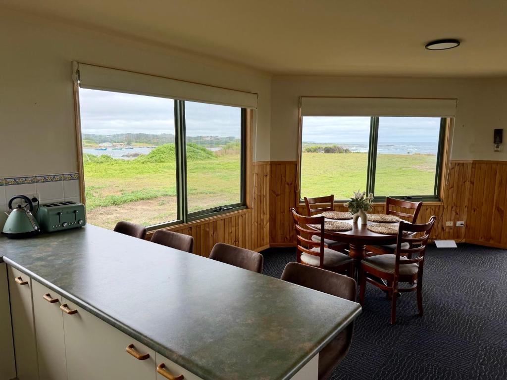 a room with a table and chairs and windows at Devils Gap in Currie
