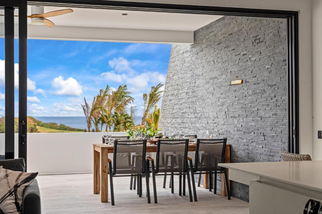 a dining room with a table and chairs with a view of the ocean at Ocean View Apartment 384 Blue Bay in Dorp Sint Michiel