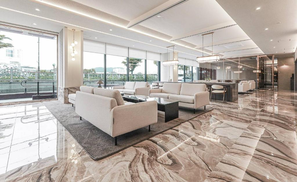 a living room with couches and a table at ALMOND Hotel in Jinju