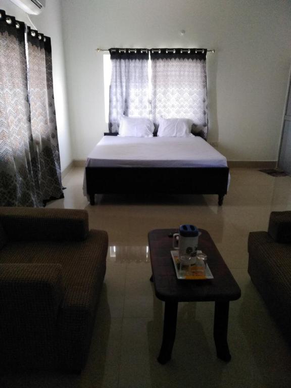 a bedroom with a bed and a coffee table at Hotel Awadh Fort in Patna