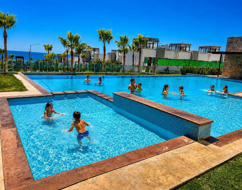 a group of people swimming in a swimming pool at Rosarito Papas & ocean view Condo in Rosarito