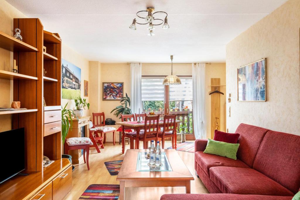 a living room with a red couch and a table at Reihenhaus Römmer in Altenstadt