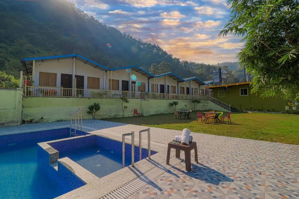 a resort with a swimming pool and a house at Prideinn Luxury Resort in Rishīkesh