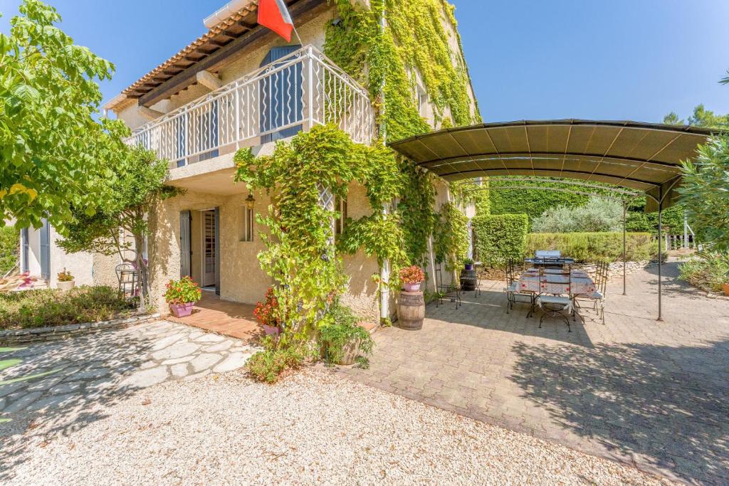 a house with a patio with a table and chairs at Chambres D'hôtes La Sousto in Châteaurenard