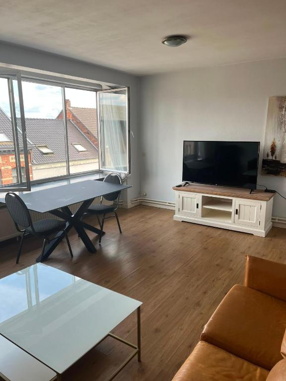 ein Wohnzimmer mit Flachbildfernseher und Sofa in der Unterkunft Basic Business Accommodation in Geel