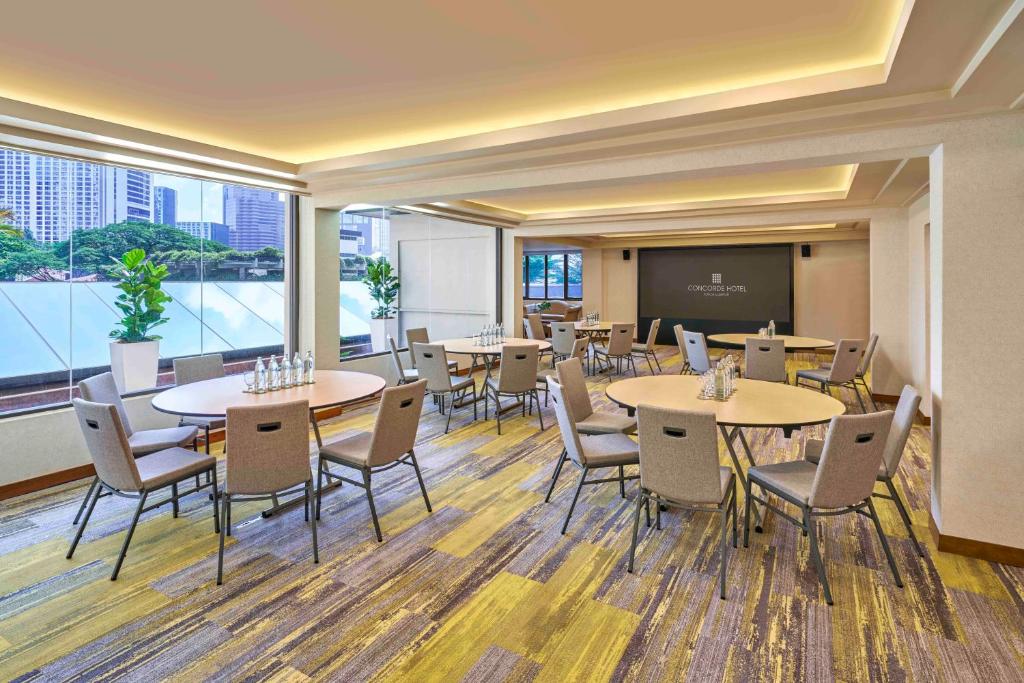A flexible event room combines round-table and classroom seating beside large windows.