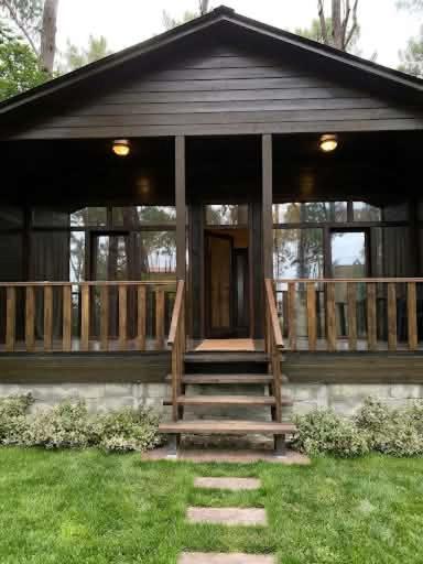 a large house with a porch and stairs in the grass at Shekvetili Cottage Nene in Shekhvetili