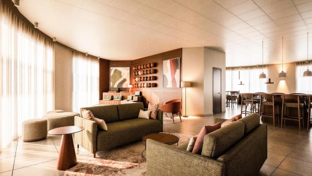 a living room with two people sitting on couches at Hotel Fiera Rimini in Rimini