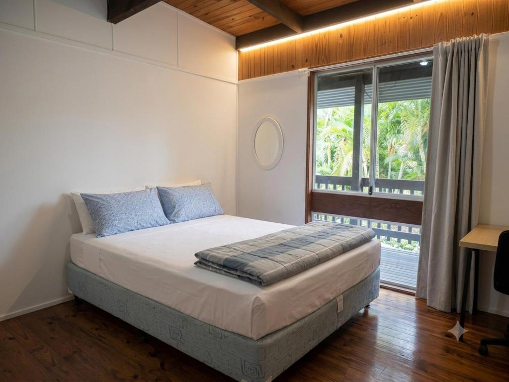 a bedroom with a bed and a large window at ALRA2 Accommodations in Brisbane