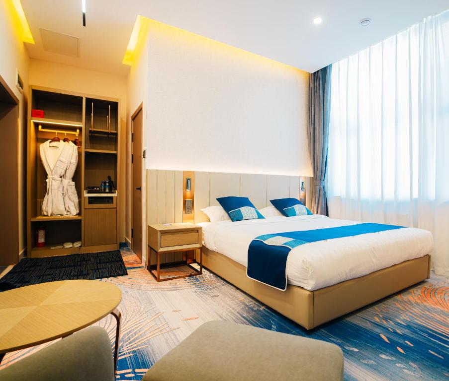 a hotel room with a bed and a table and chairs at Zenn Hotel Erdenet in Erdenet