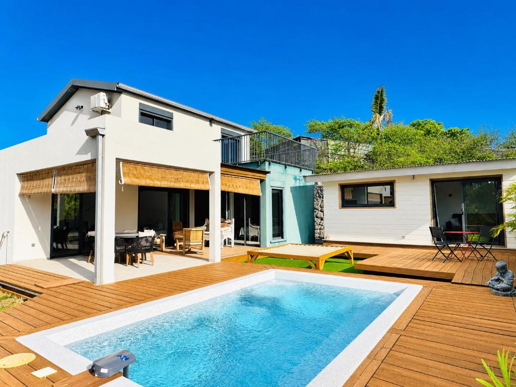 a backyard with a swimming pool and a house at Villa Parenthèse - Piscine & Bungalow - 8 Pers in Trois Bassins