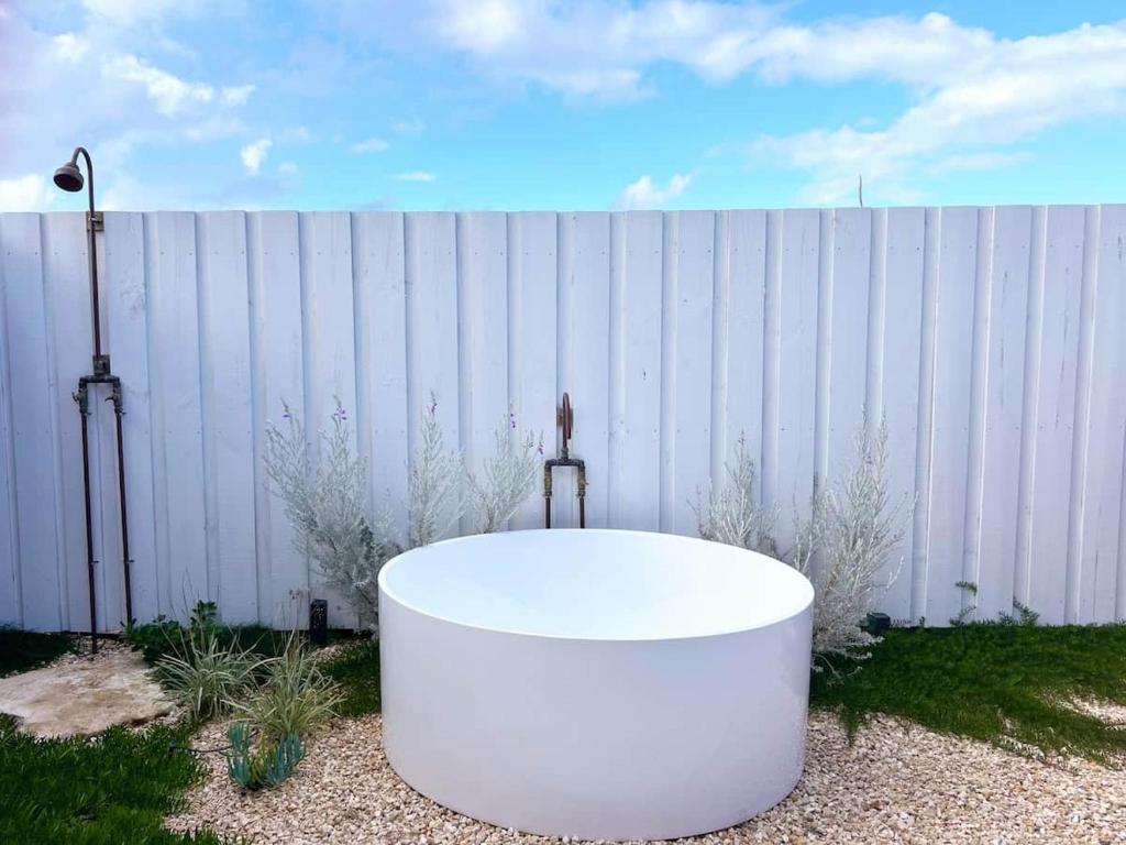 a white bath tub sitting in front of a fence at Studio Jean - Dog-Friendly in Bremer Bay