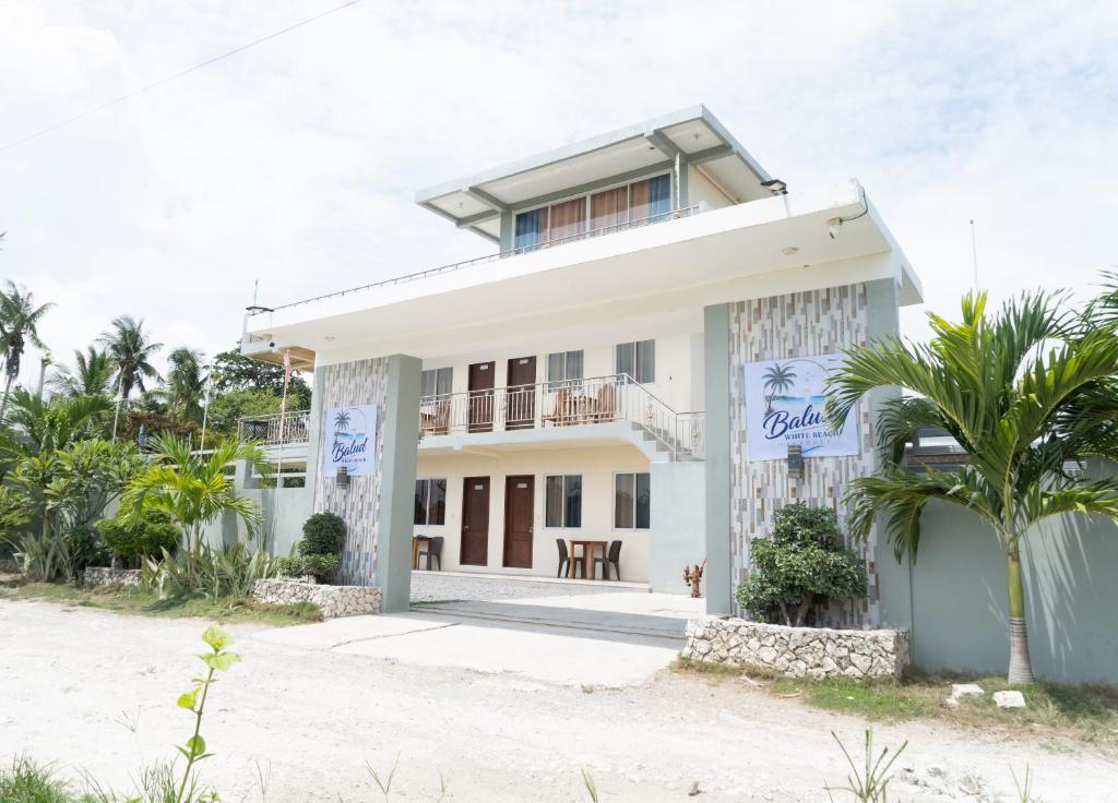 a house on the beach with a palm tree at Balud White Beach Resort in Moalboal