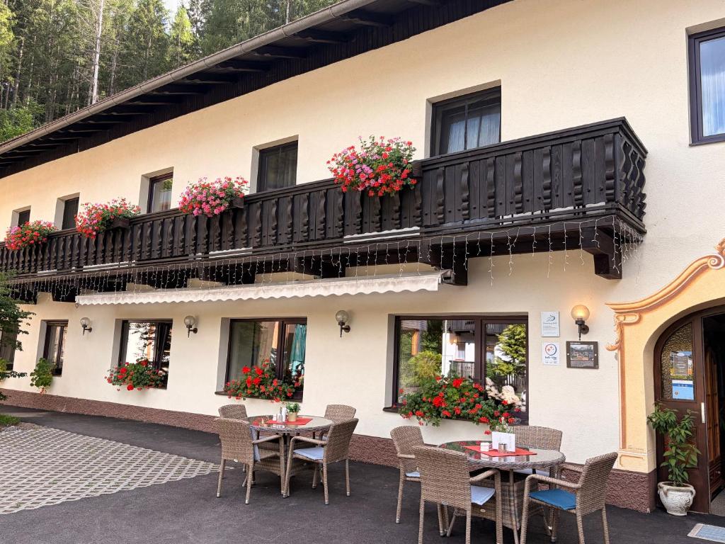 a building with tables and chairs and a balcony at Waldhotel Bad Jungbrunn in Tristach