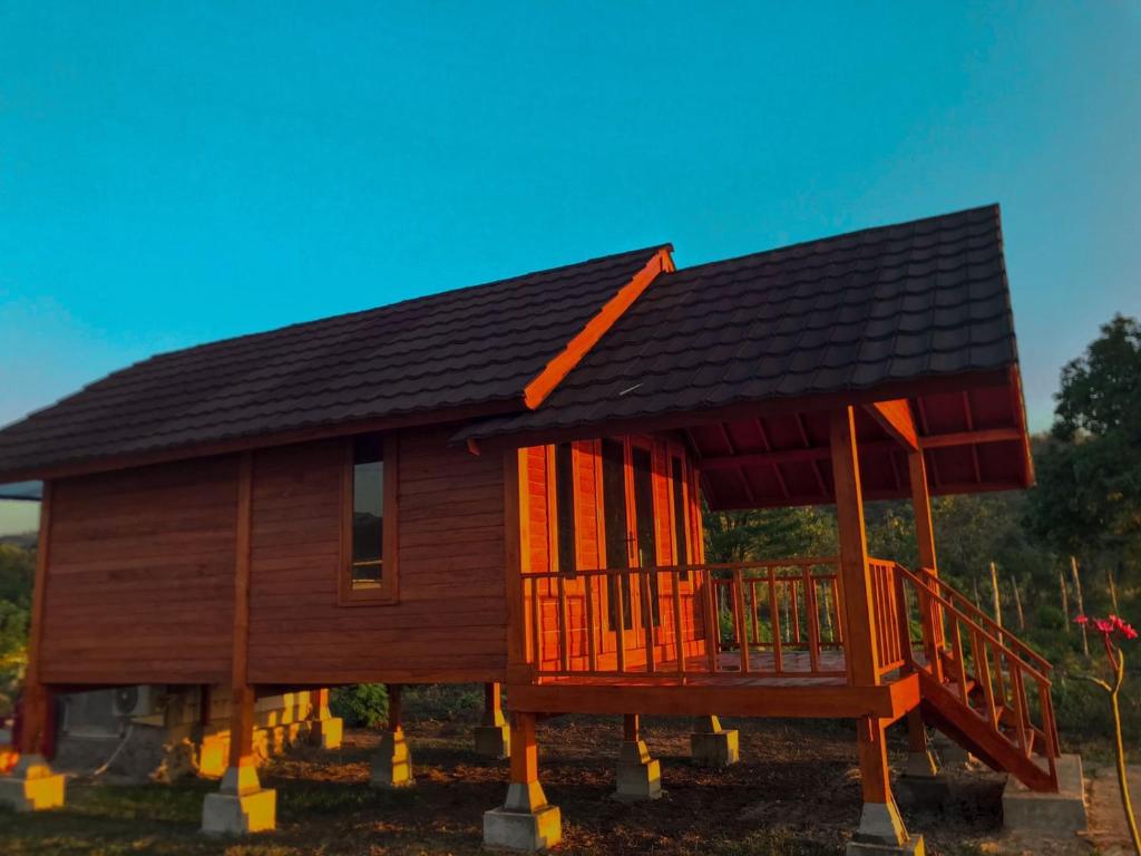 a wooden house with a gambrel roof at Anorawi Supersuck Surf Accommodation in Maluk