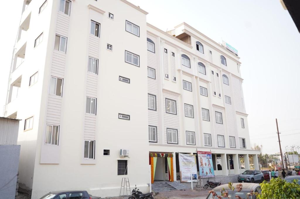 a large white building with a lot of windows at Hindustan Hotels in Warangal