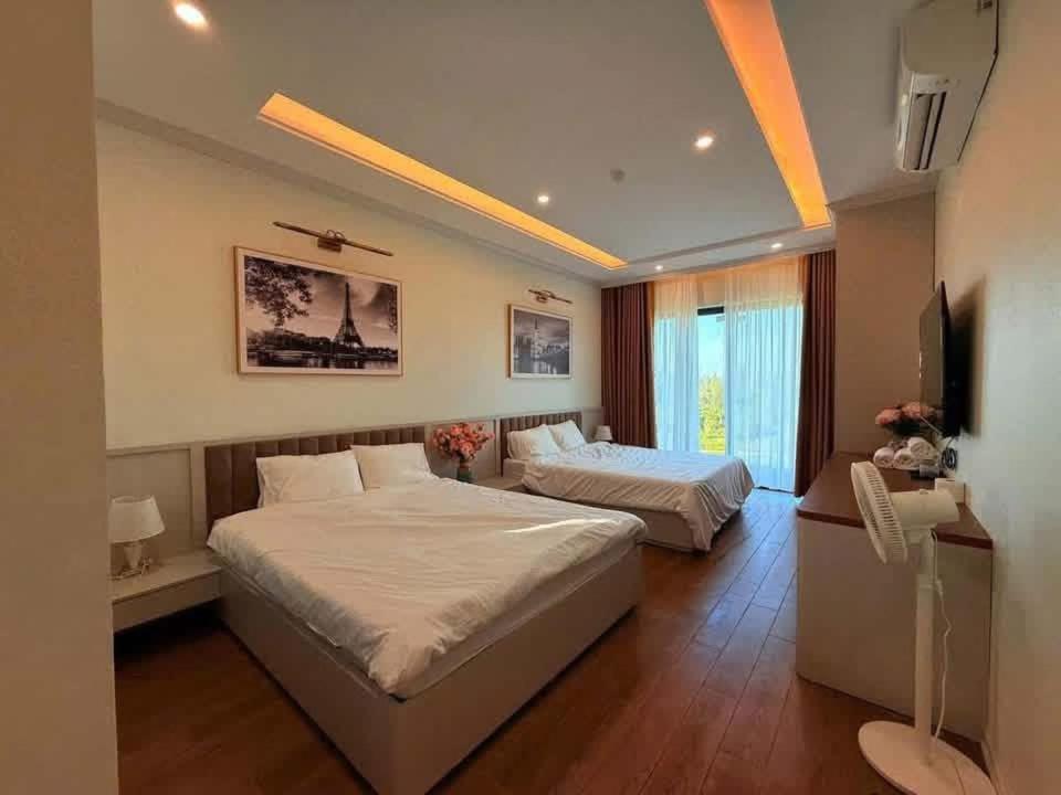 a bedroom with two beds and a flat screen tv at Huong Sky Co To in Chung Cap
