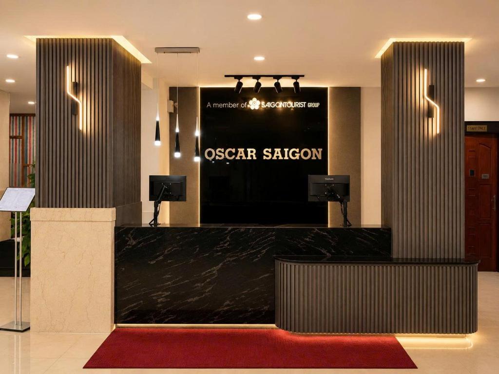 a hotel lobby with a reception desk with a red carpet at Oscar Saigon Hotel in Ho Chi Minh City