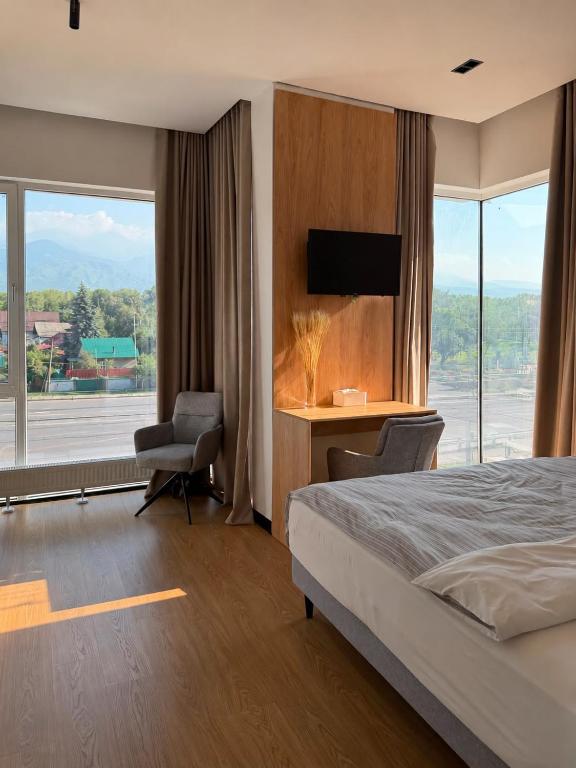 a bedroom with a bed and a desk and a window at Mosh Mosh Boutique Hotel in Almaty