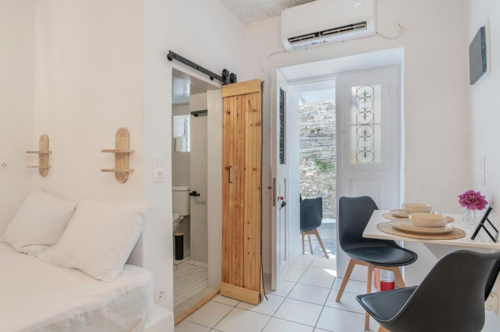 a room with a bed and a table and chairs at Bougainvillea in Andros