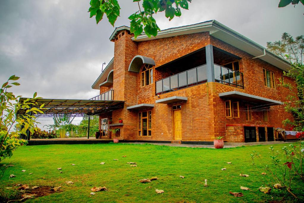 a large brick building with a grass yard in front of it at Tranquil Hillhouse in Nkoanrua
