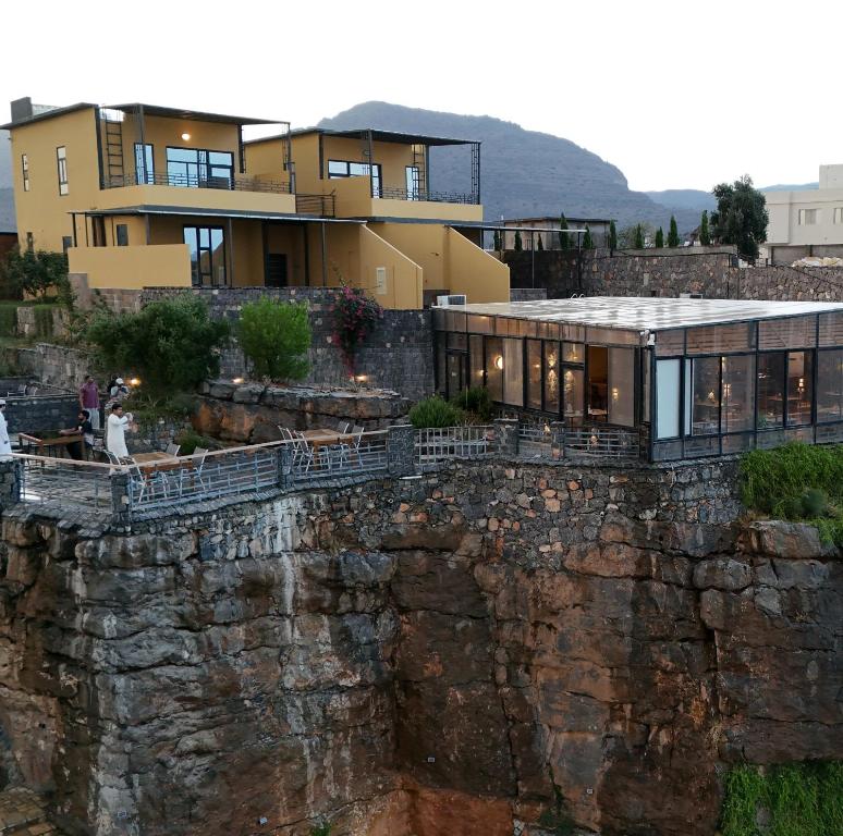 a house on top of a rock wall at ALOEVERA VILLAS & CAFA in Sayq