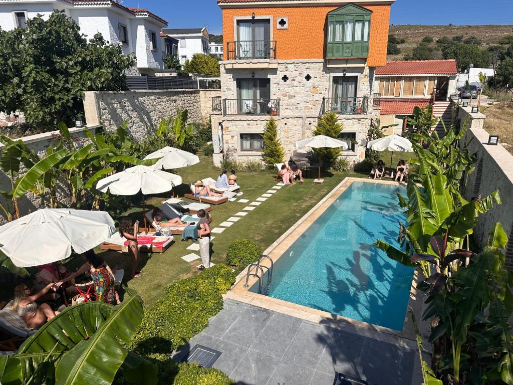 a group of people sitting around a pool at a hotel at Elia Hotel Alaçatı in Çeşme