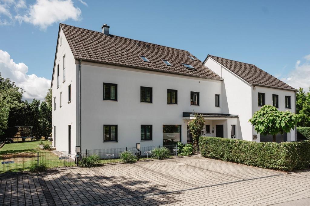 ein weißes Haus mit schwarzem Dach in der Unterkunft Gästehaus Lodermeier in Bad Abbach