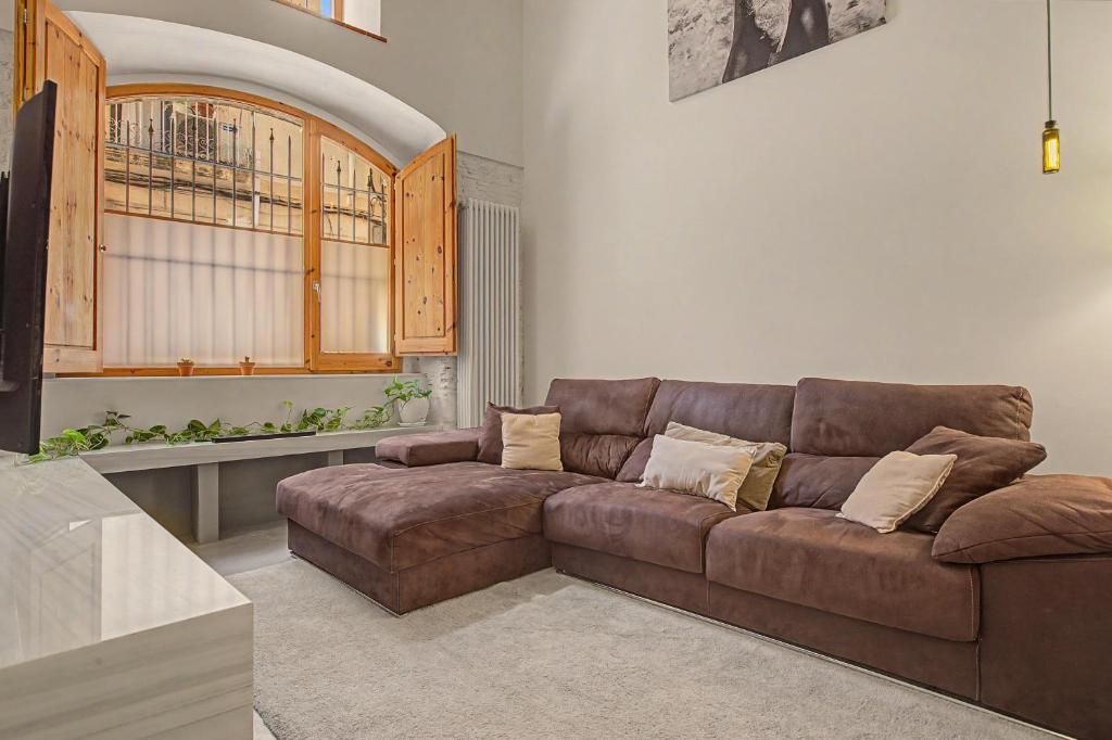 a living room with a brown leather couch at Casa Elegante in Vilanova i la Geltrú