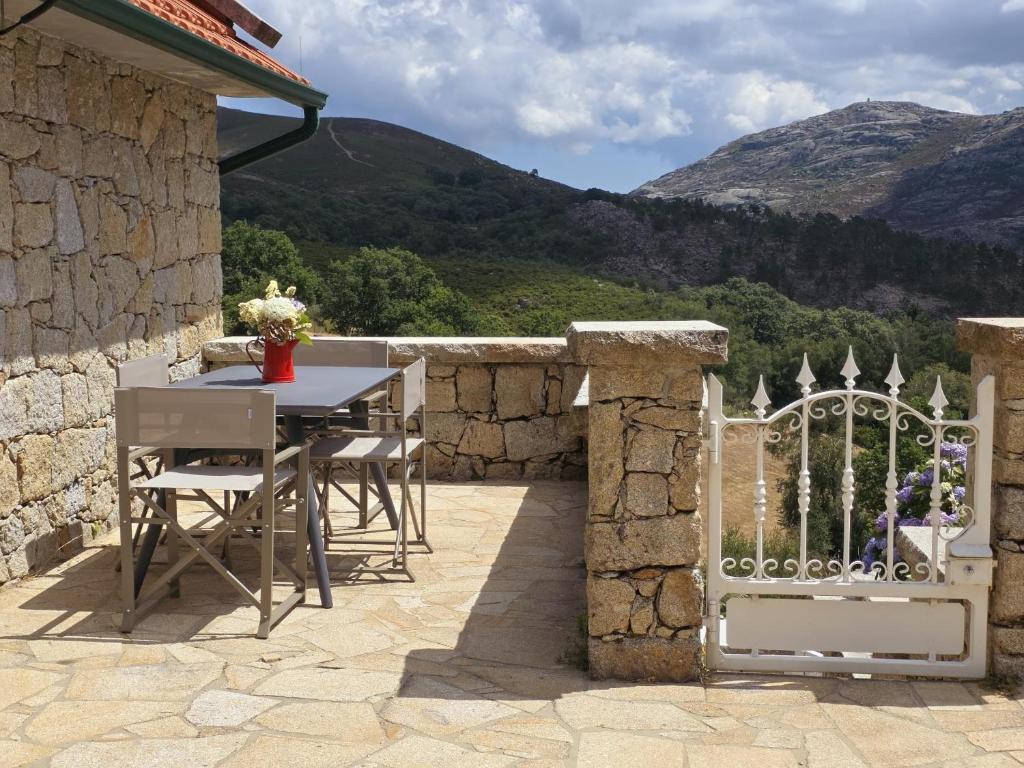 a patio with a table and chairs and a fence at Refúgio do Zé Espanhol in Arcos de Valdevez