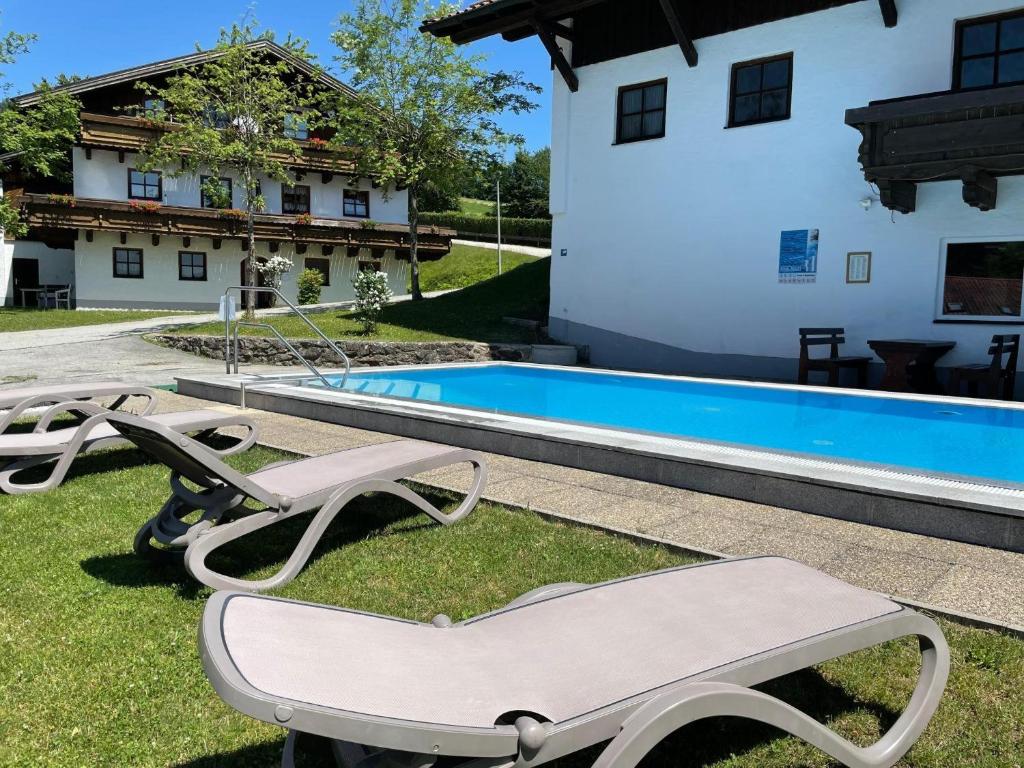 a pair of lounge chairs next to a swimming pool at Feriendorf Hauzenberg-Pool&Sauna in Hauzenberg
