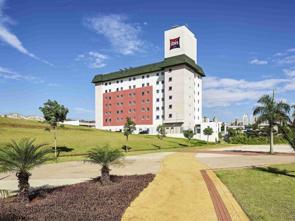 a large white building with a green roof at ibis Londrina Shopping in Londrina
