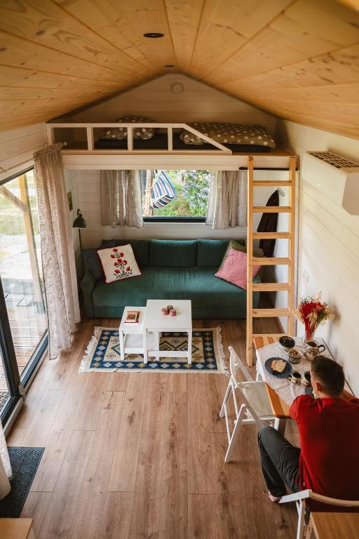 a person sitting at a table in a tiny house at Jemiołucha Glamping in Bodzentyn