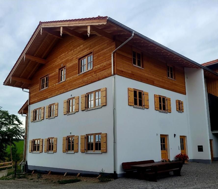 a large white building with a wooden roof at Ferienhof Winkler in Bernbeuren