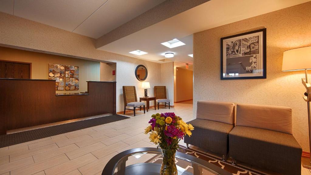 una sala de espera con sofá y flores en una mesa en Days Inn by Wyndham Indiana Benjamin Franklin Highway, en Indiana