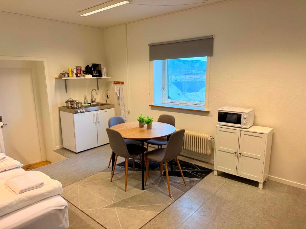 a kitchen with a table and chairs in a room at Ilulissat Harbour Stay in Ilulissat