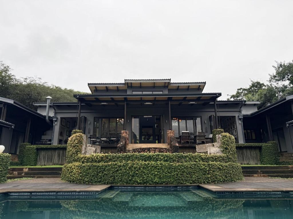 a house with a swimming pool in front of a house at Seldom Seen in Malelane