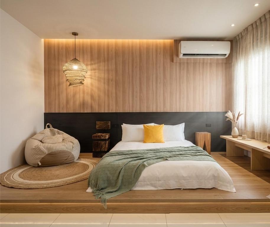 a bedroom with a large bed with a wooden floor at Ho.Me-Easyhouse in Tainan
