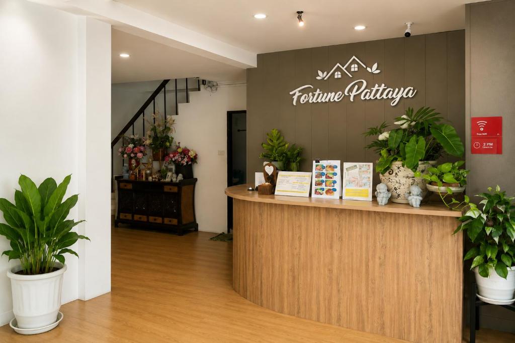 a cashier counter in a store with potted plants at Fortune Pattaya Resort in Jomtien Beach