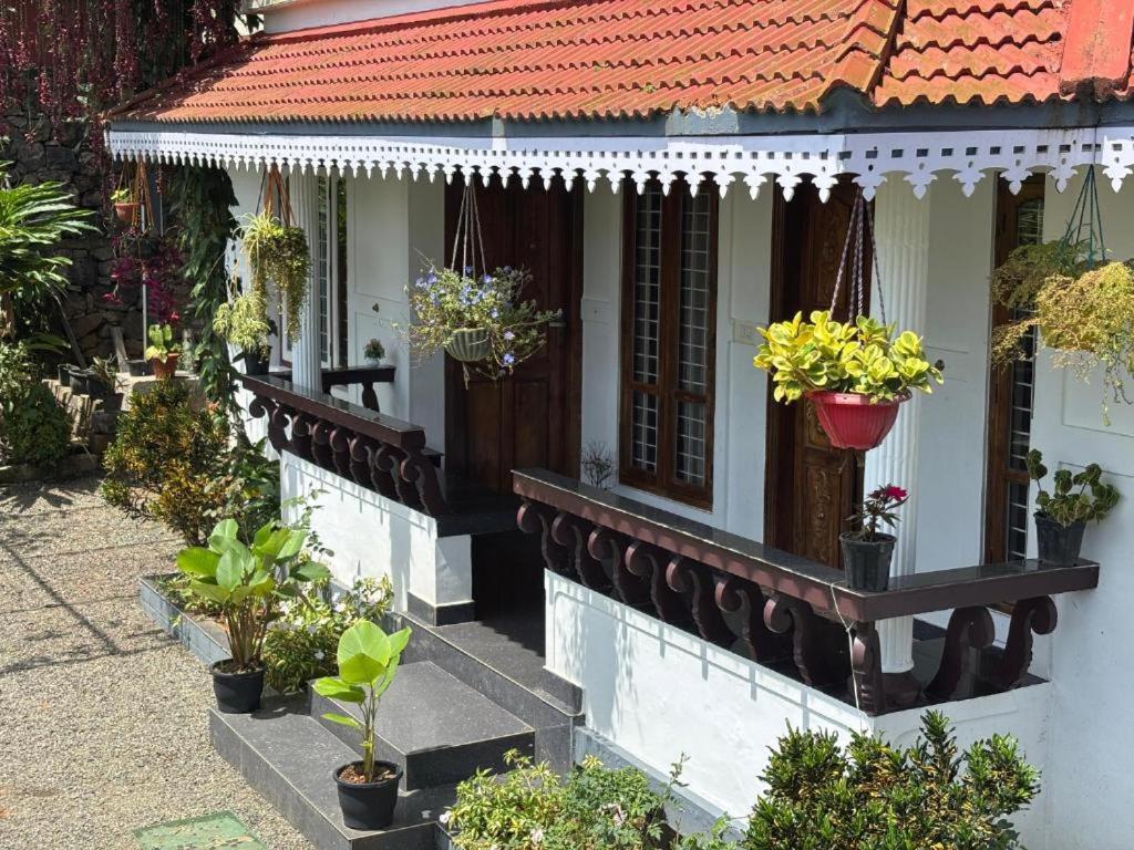 a house with potted plants on the side of it at Homestay INN in Anachal