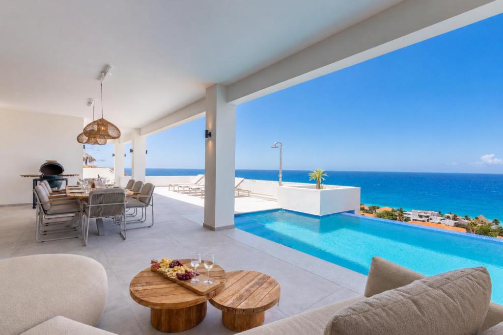 an open living room with a pool and ocean views at Villa Dushi Brisa 650 - Coral Estate in Willibrordus