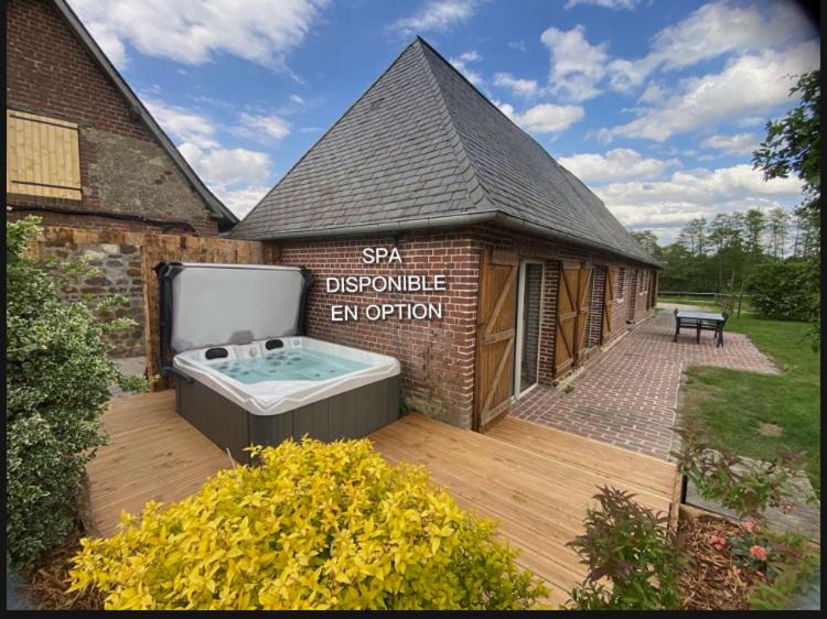 a building with a hot tub on a wooden deck at Gite Ô pré in Beaubec-la-Rosière