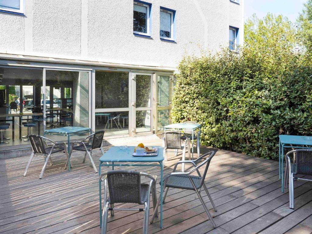 a patio with tables and chairs on a deck at ibis budget Arles Sud Fourchon in Arles