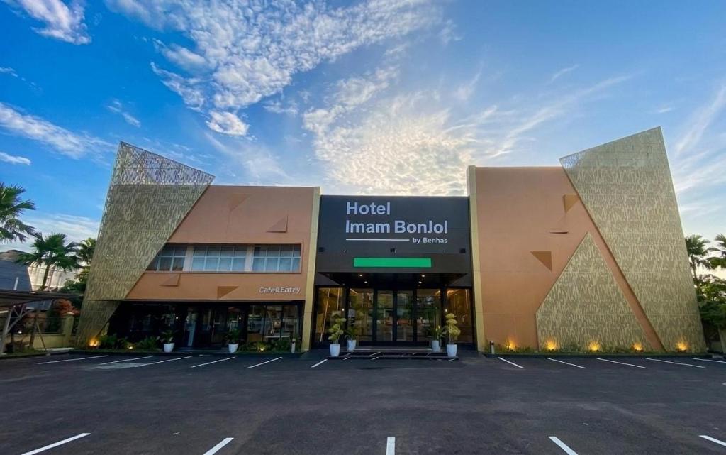 a building with a parking lot in front of it at Hotel Imam Bonjol by Benhas in Padang