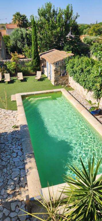 a swimming pool in a yard with a house at Aux Pots Bleus in Nissan-lez-Enserune