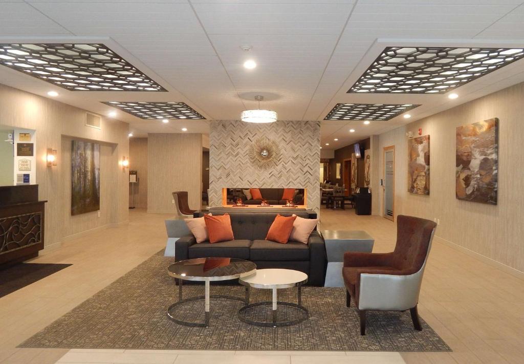 a lobby with a couch and a table and chairs at Best Western Plus Bradford Inn in Bradford