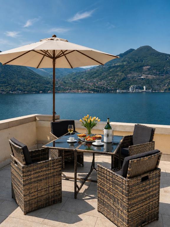 a table and chairs with an umbrella on a patio at Casa PG - Appartamento Vista Lago in Monte Isola